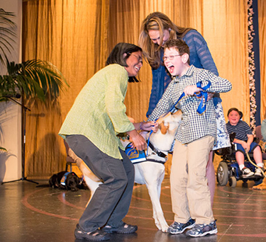 young boy receiving his assistance dog